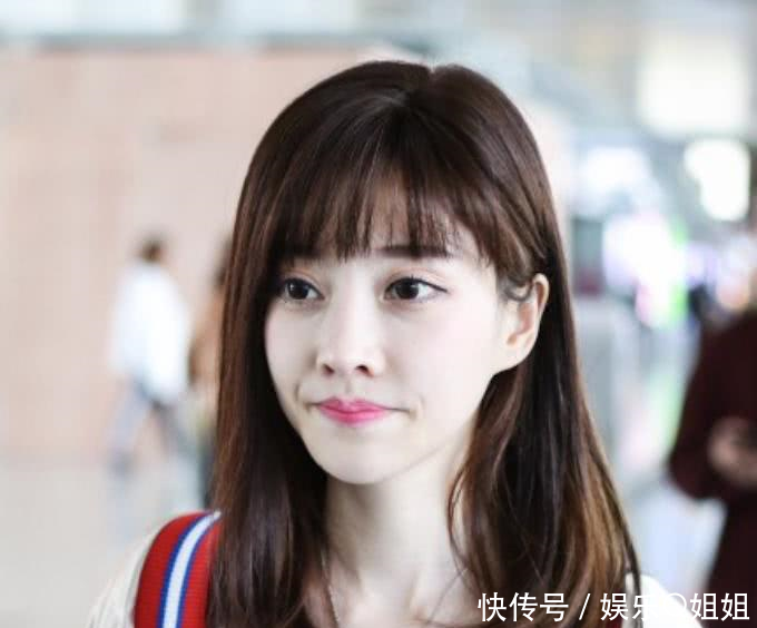 冯提莫现身机场,身穿米色外套搭配白色连衣裙