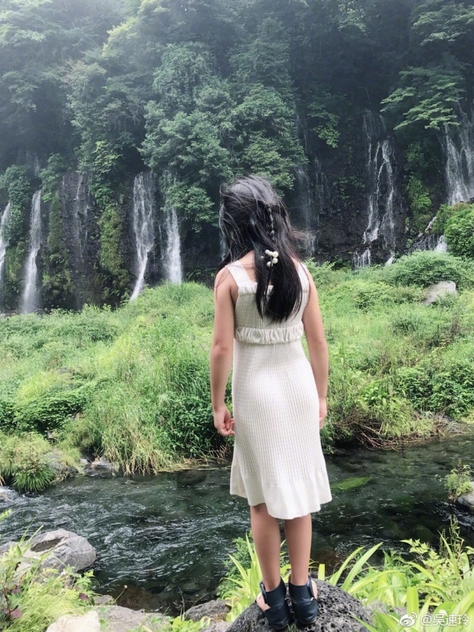 曹格女儿站在瀑布边背影